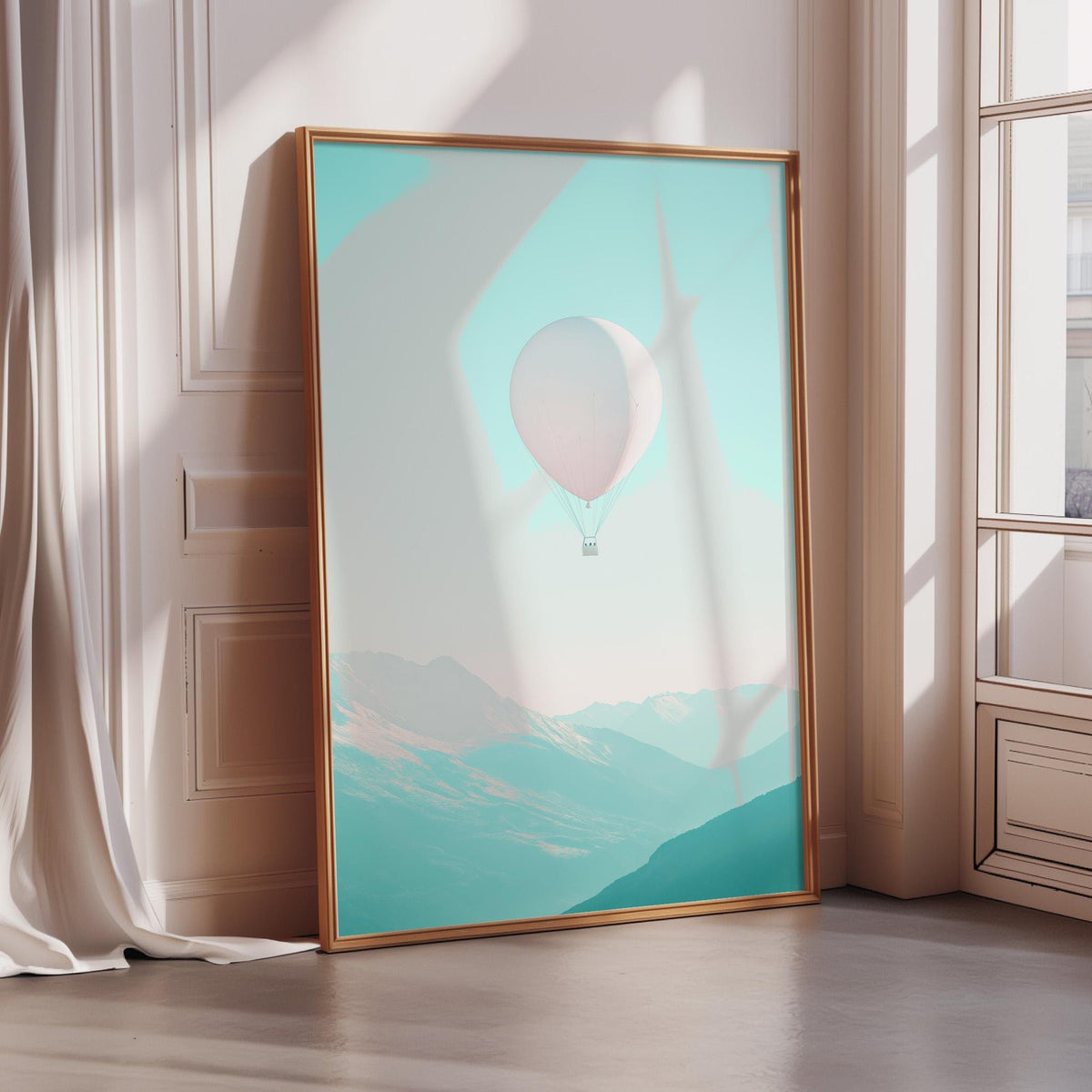 A large framed poster depicting a hot air balloon floating in a mountainous landscape, with a pale blue sky and green mountains in the background.