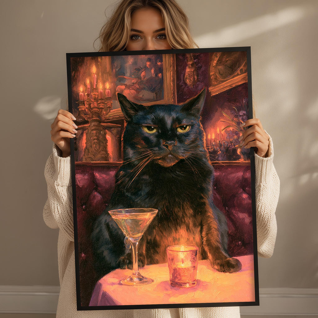A woman holds up a framed painting depicting a black cat sitting at a table with a martini glass and a candle, surrounded by a warm, cozy atmosphere.