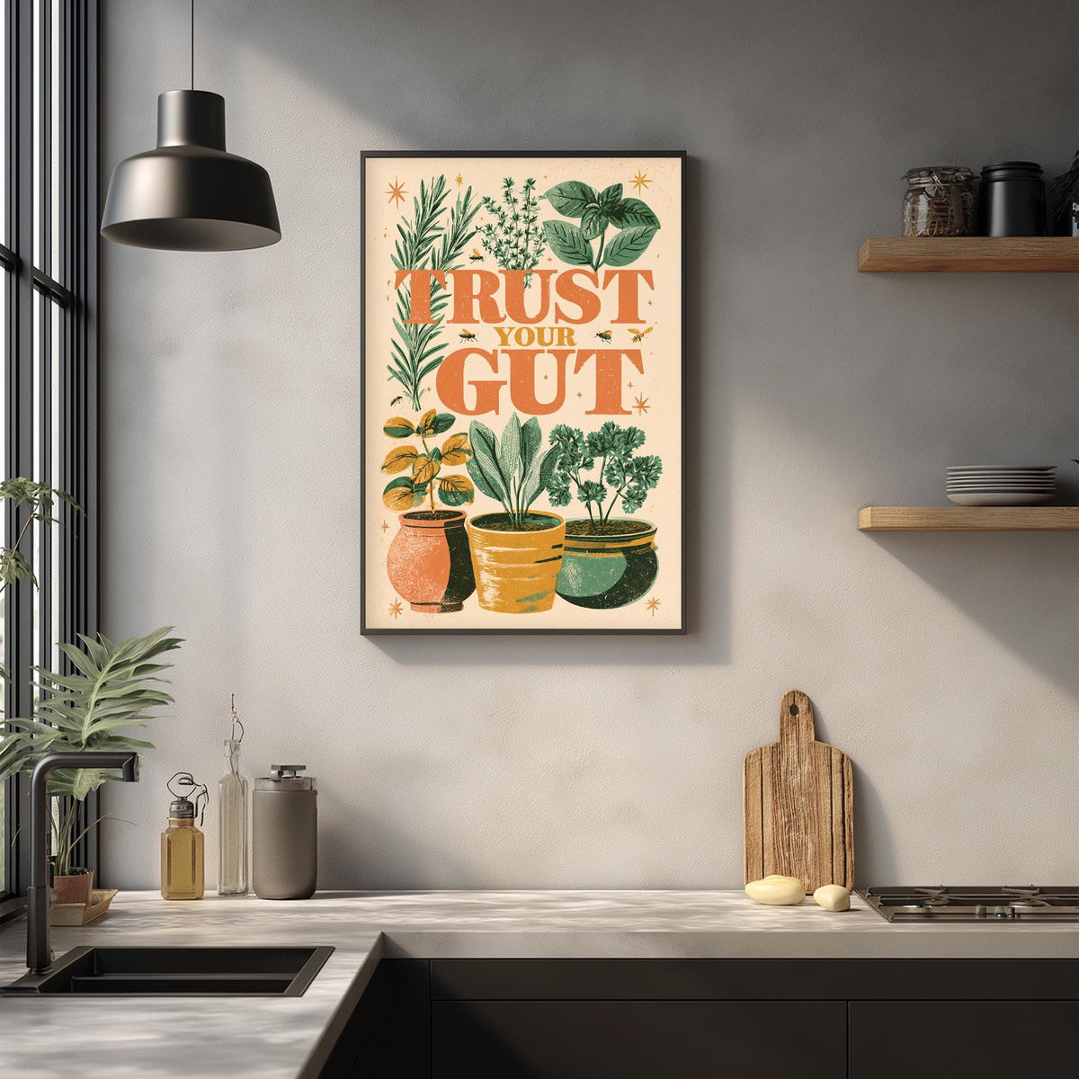 a kitchen counter with various kitchen items, including a cutting board, a sink, and a potted plant. Above the counter, there is a framed poster with the text "TRUST YOUR GUT" and illustrations of plants and flowers.