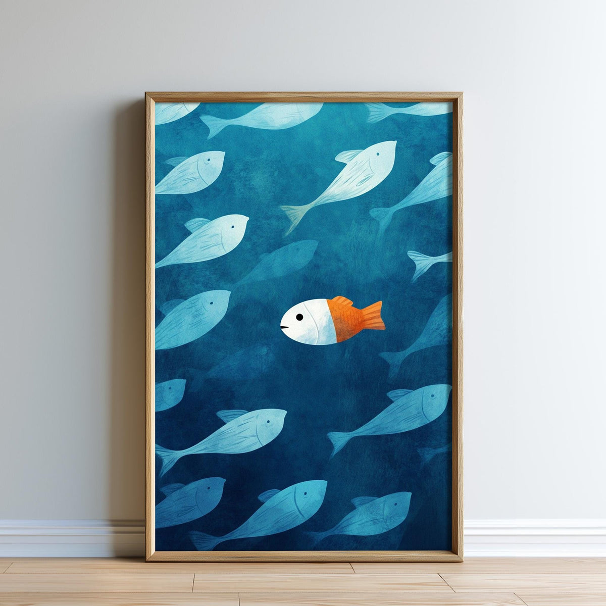 The image is a framed artwork depicting a group of fish swimming in the ocean, with one orange fish standing out among the blue and white fish.