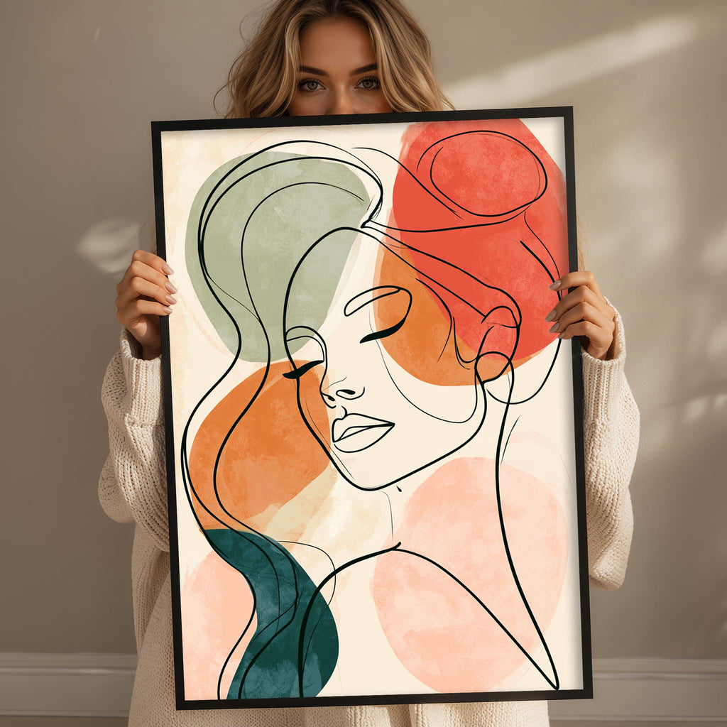 A woman holding a framed abstract drawing of a woman's face.