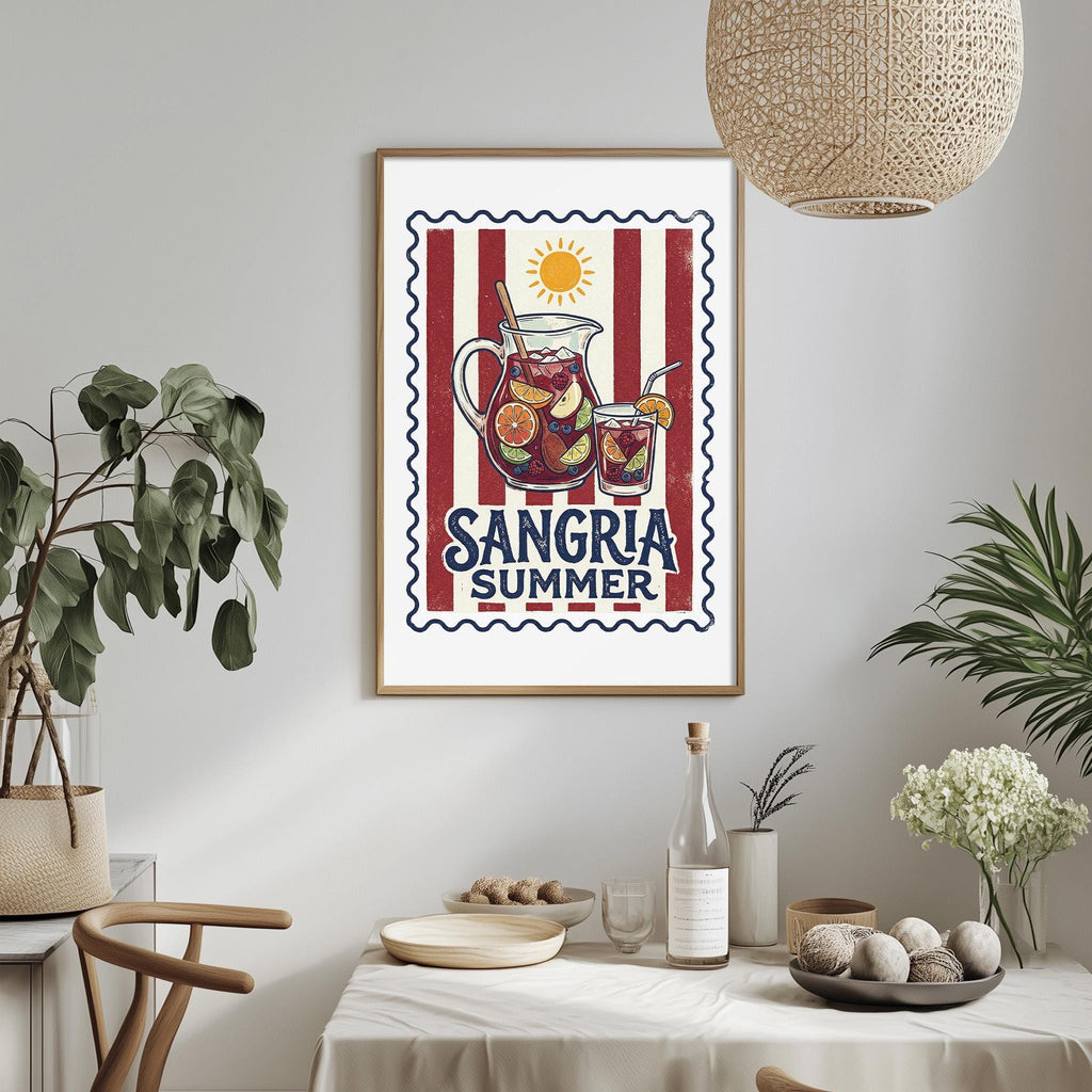 a framed poster of a pitcher of Sangria, a summer drink, hanging on a wall above a dining table with various items on it.