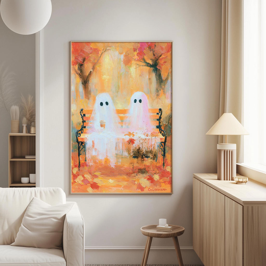 a living room with a large painting of two ghostly figures sitting on a bench, surrounded by autumn foliage. The painting is hung on the wall above a white couch, and there is a lamp and a small table nearby.