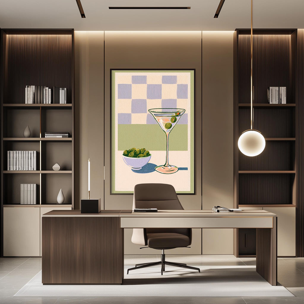 a modern office space with a large framed artwork of a martini glass and a bowl of fruit on the wall. The office features a wooden desk, a comfortable-looking chair, and a bookshelf filled with books. The overall design and decor create a stylish and professional atmosphere.