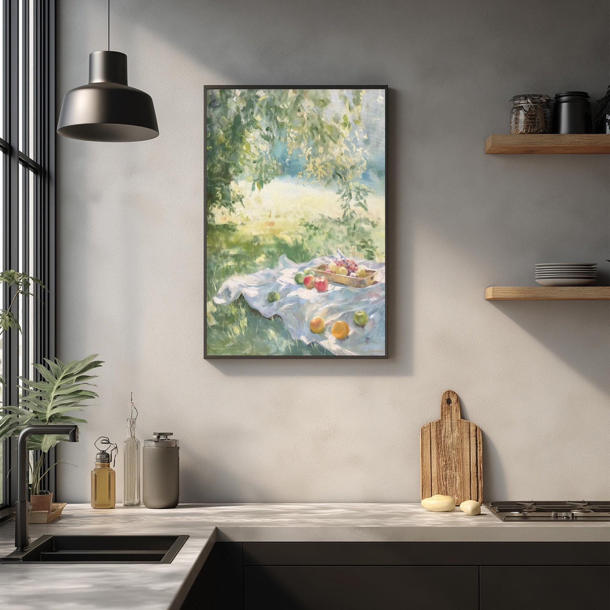a kitchen counter with a framed painting of a picnic scene hanging above it. The painting depicts a picnic with a blanket, fruit, and a basket of food. The kitchen counter has various items on it, including a cutting board, a bottle, and a bowl.