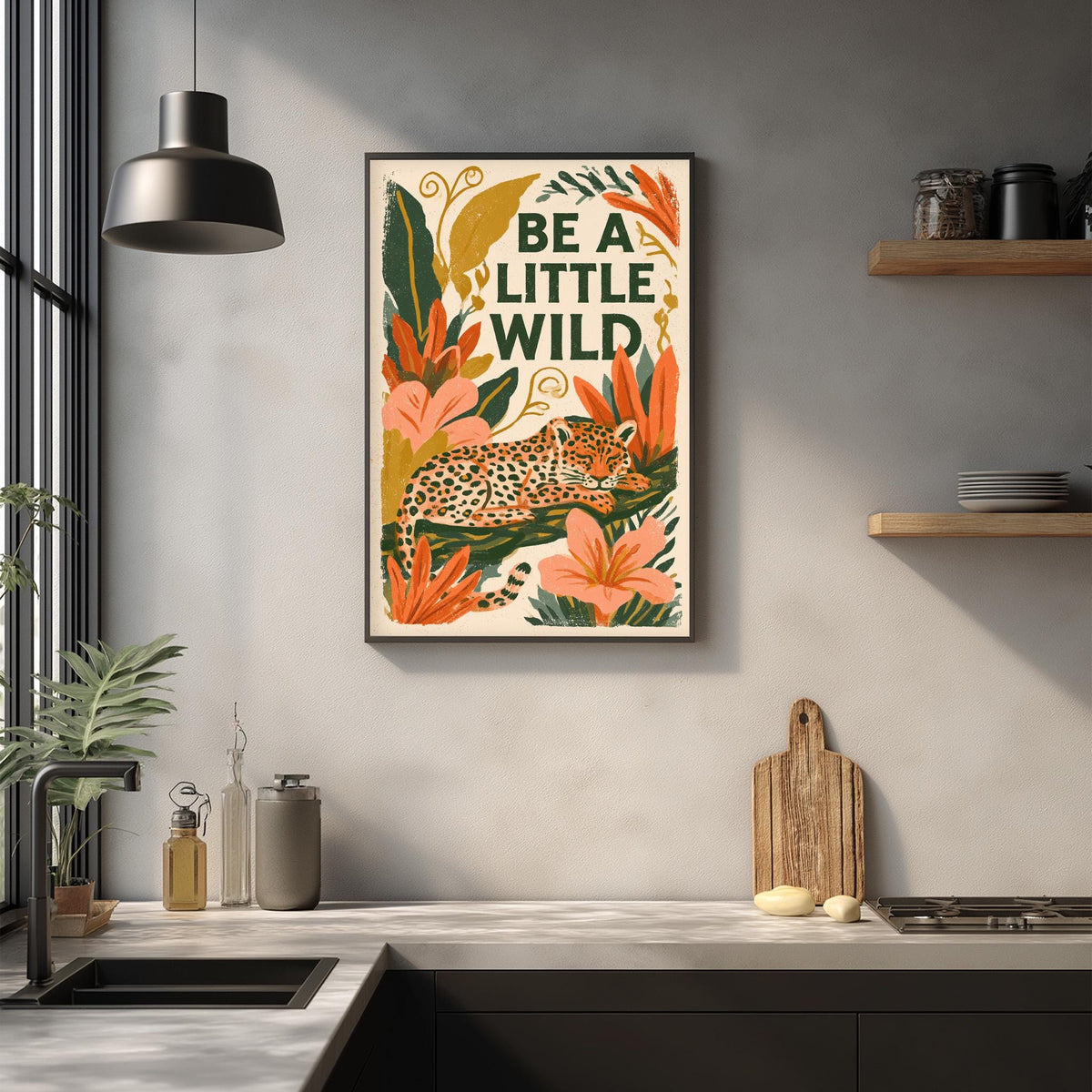 a kitchen counter with a framed poster of a leopard surrounded by tropical plants and flowers, along with a wooden cutting board and other kitchen items.
