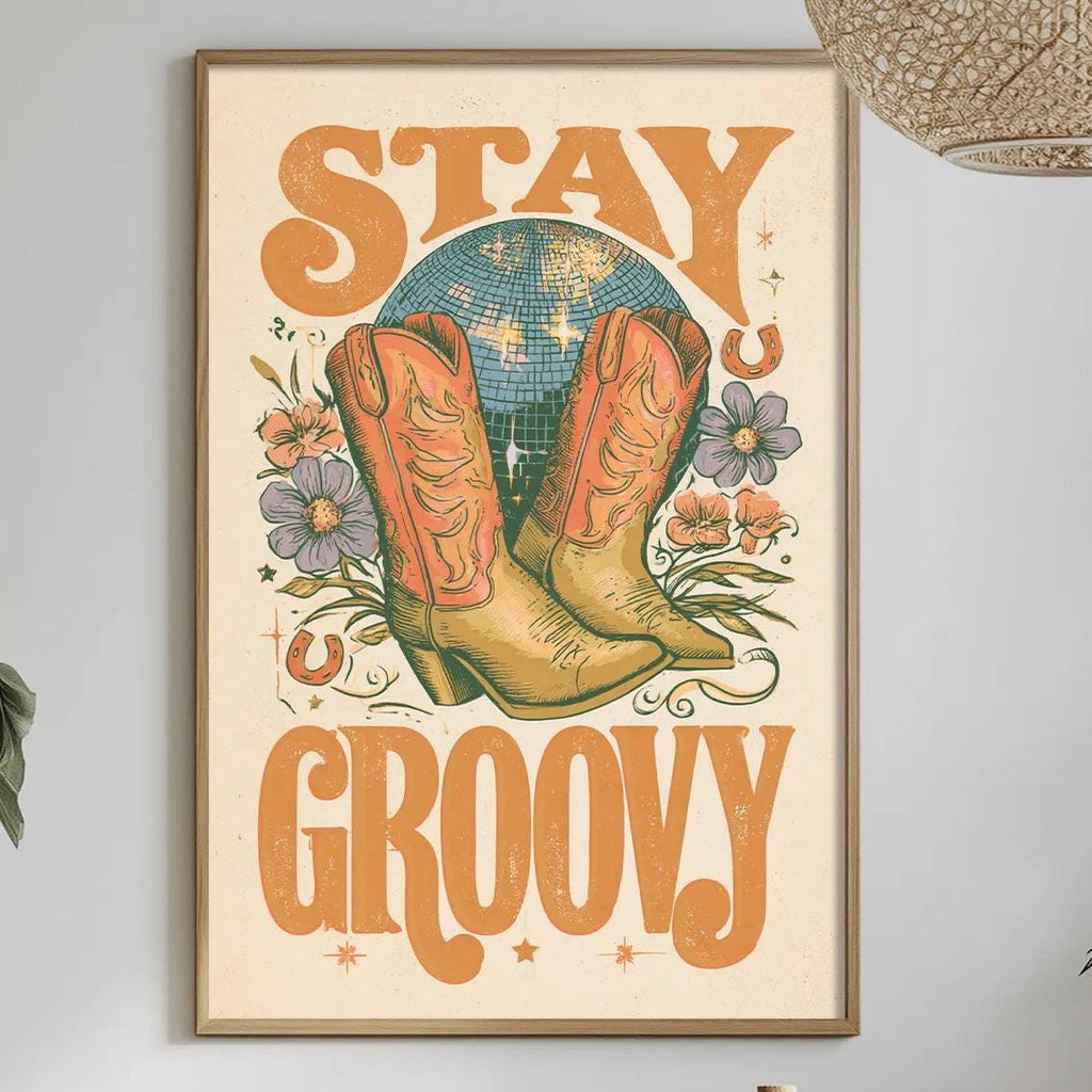 a framed poster with the text "STAY GROOVY" hanging on a wall above a dining table with various items on it, including a bottle, a bowl, and a vase.
