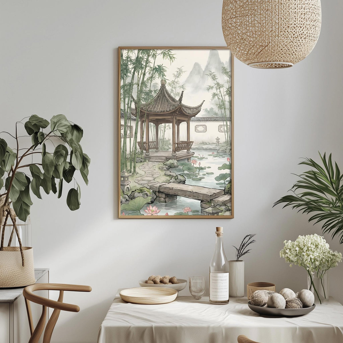 a serene oriental garden scene with a pagoda, bamboo trees, and a pond, all framed and hung on a wall. The table is set with a vase of white flowers, a bottle, and a bowl of fruit, creating a peaceful and inviting atmosphere.