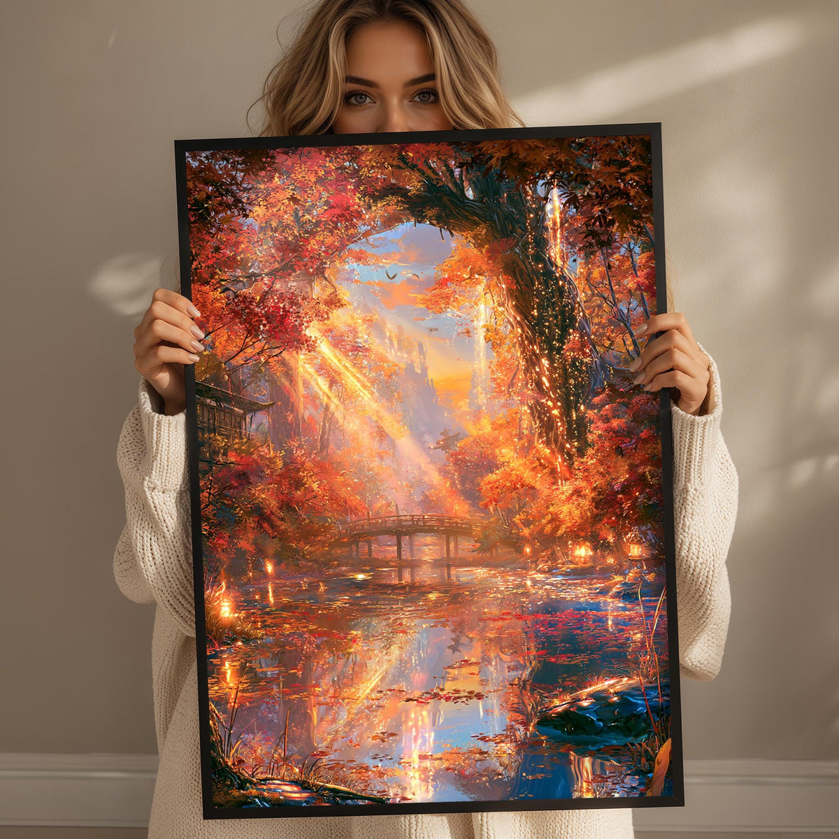 A woman holds up a framed painting depicting a vibrant autumn landscape with a pond, trees, and a bridge.