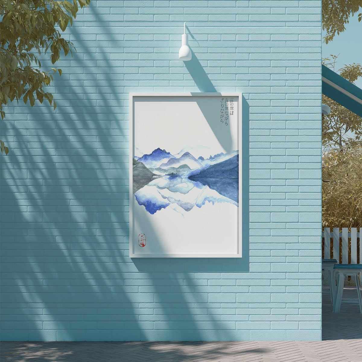 a blue brick wall with a framed painting of a mountain landscape hanging on it.