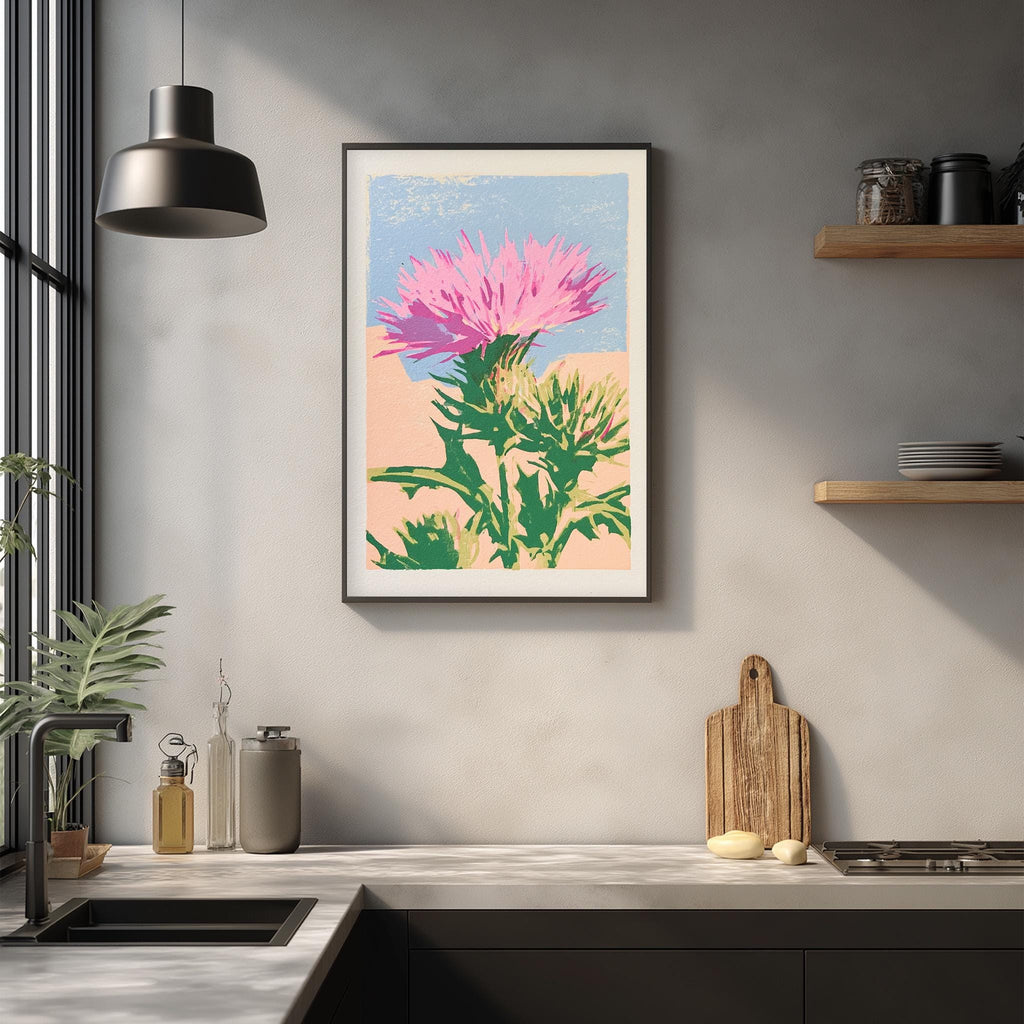 a kitchen counter with a framed print of a pink flower on the wall above it. The counter also has various kitchen items such as a cutting board, a knife, and a bottle.