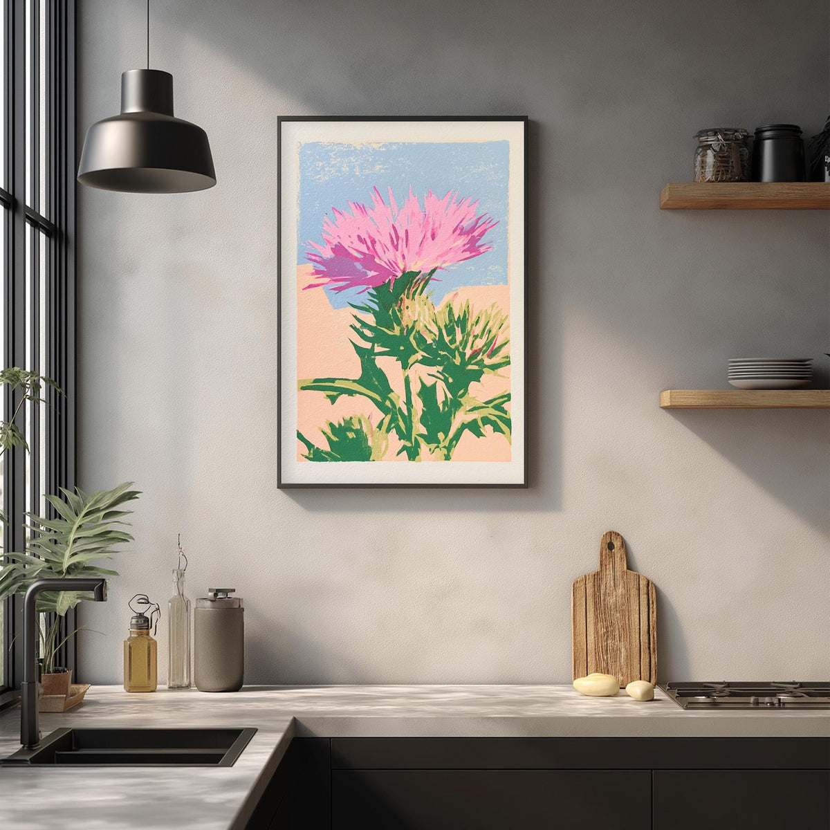 a kitchen counter with a framed print of a pink flower on the wall above it. The counter also has various kitchen items such as a cutting board, a knife, and a bottle.