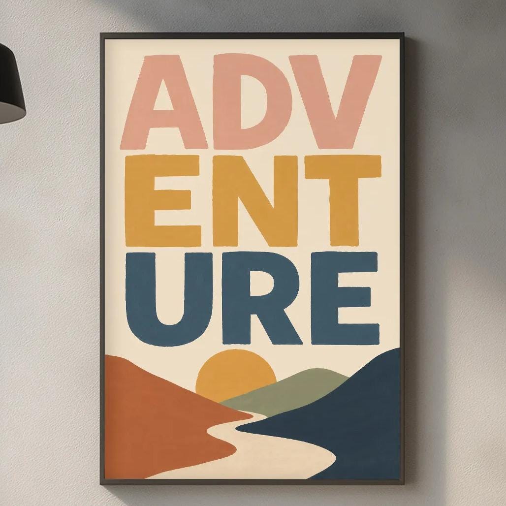 a kitchen counter with a framed poster of a mountain landscape hanging above it. The poster has the words "ADVENTURE" written on it in bold letters. The kitchen counter also has various items such as a cutting board, a bottle, and a plant.