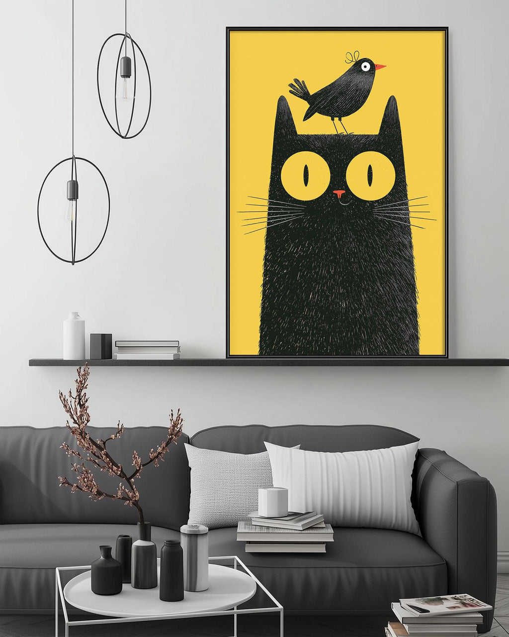 a cozy living room with a gray couch, a coffee table, and a large framed illustration of a black cat with a bird perched on its head. The room has a minimalist and modern design, with a black and white color scheme and a few decorative elements such as a potted plant and a vase.