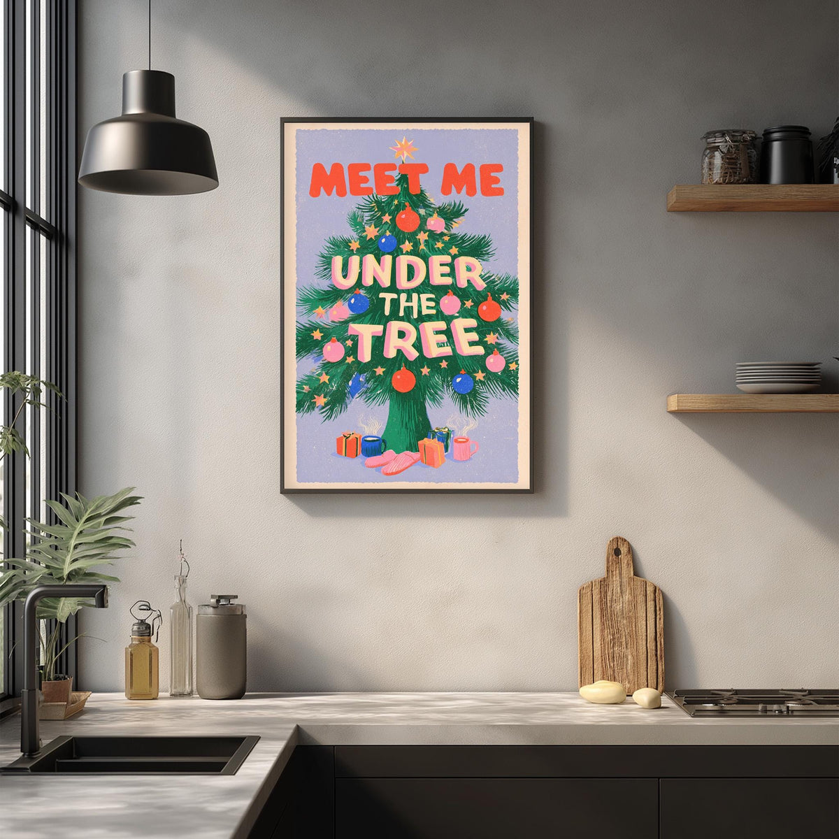 a kitchen counter with a framed poster hanging on the wall above it. The poster has a colorful design with a Christmas tree and the text "Meet me under the tree".
