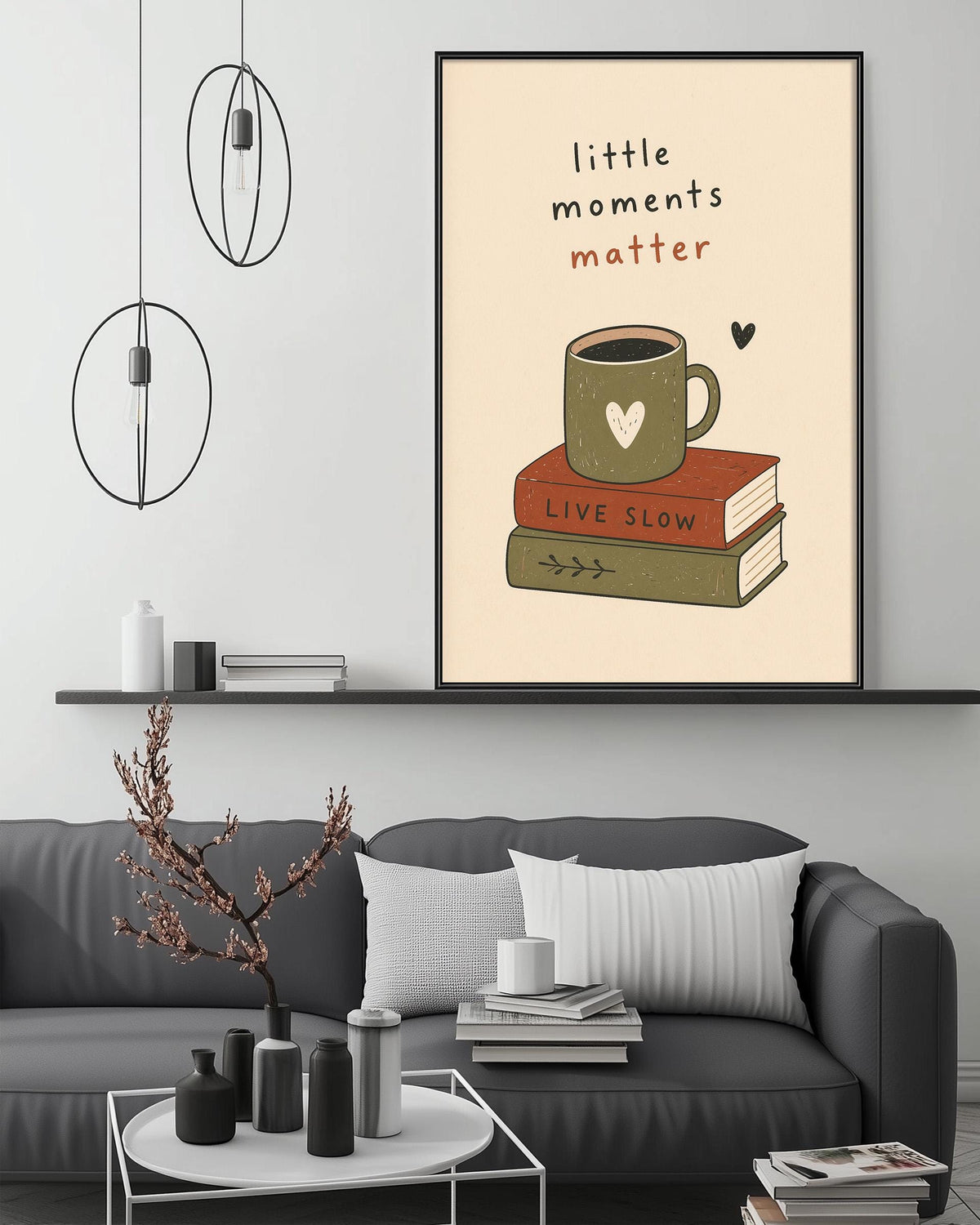 a cozy living room with a gray couch, a coffee table, and a framed poster on the wall. The poster has a coffee mug and a book illustration, along with the text "little moments matter" and a heart symbol.