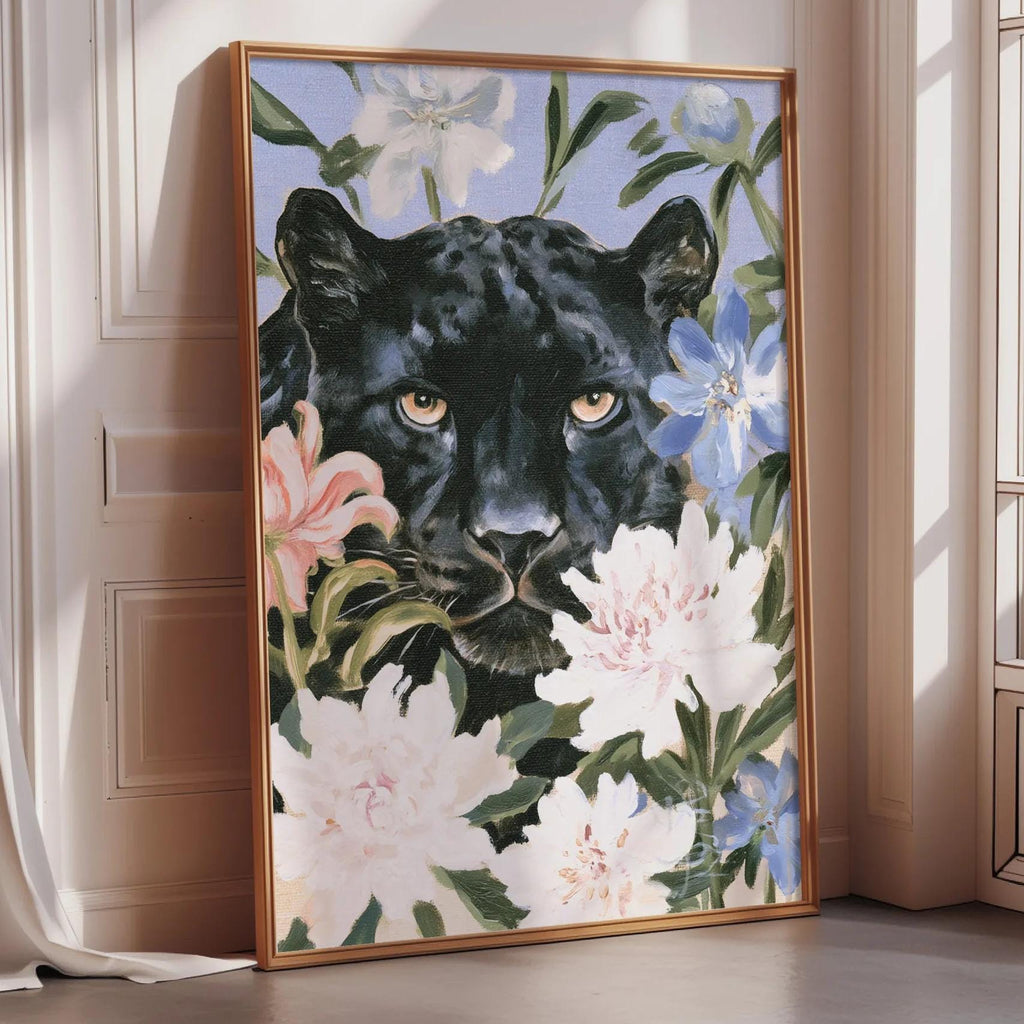 A framed painting of a black panther surrounded by colorful flowers is displayed on a wall in a room.
