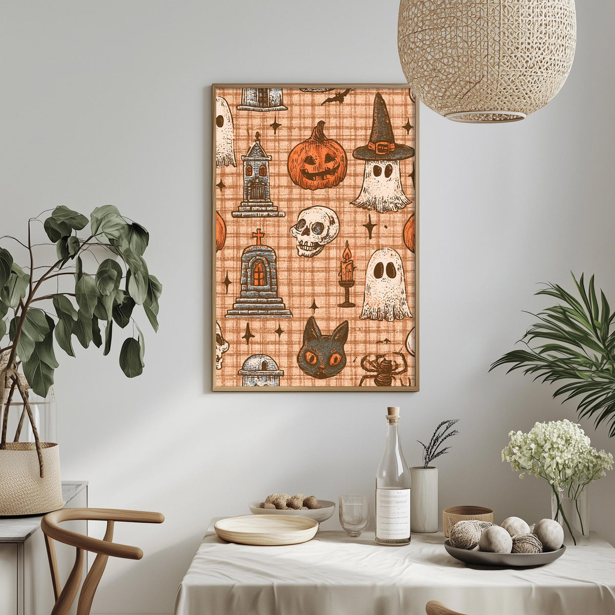 a Halloween-themed wall art with various spooky and ghostly illustrations, including a jack-o-lantern, a witch's hat, a skeleton, a ghost, and a cat. The wall art is displayed above a dining table with a white tablecloth, and there are potted plants and other decorative items on the table.