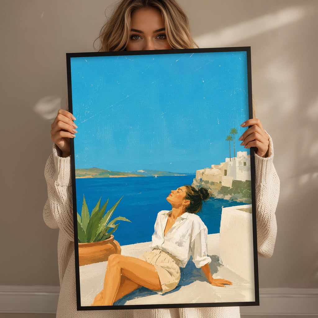 A woman holding a framed painting of a woman sitting on a balcony overlooking the ocean.