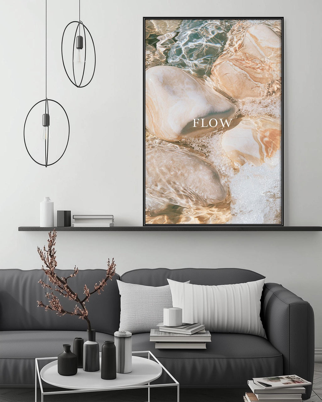 a modern living room with a gray sofa, a coffee table, and a large framed print of a beach scene with the word "FLOW" written on it.