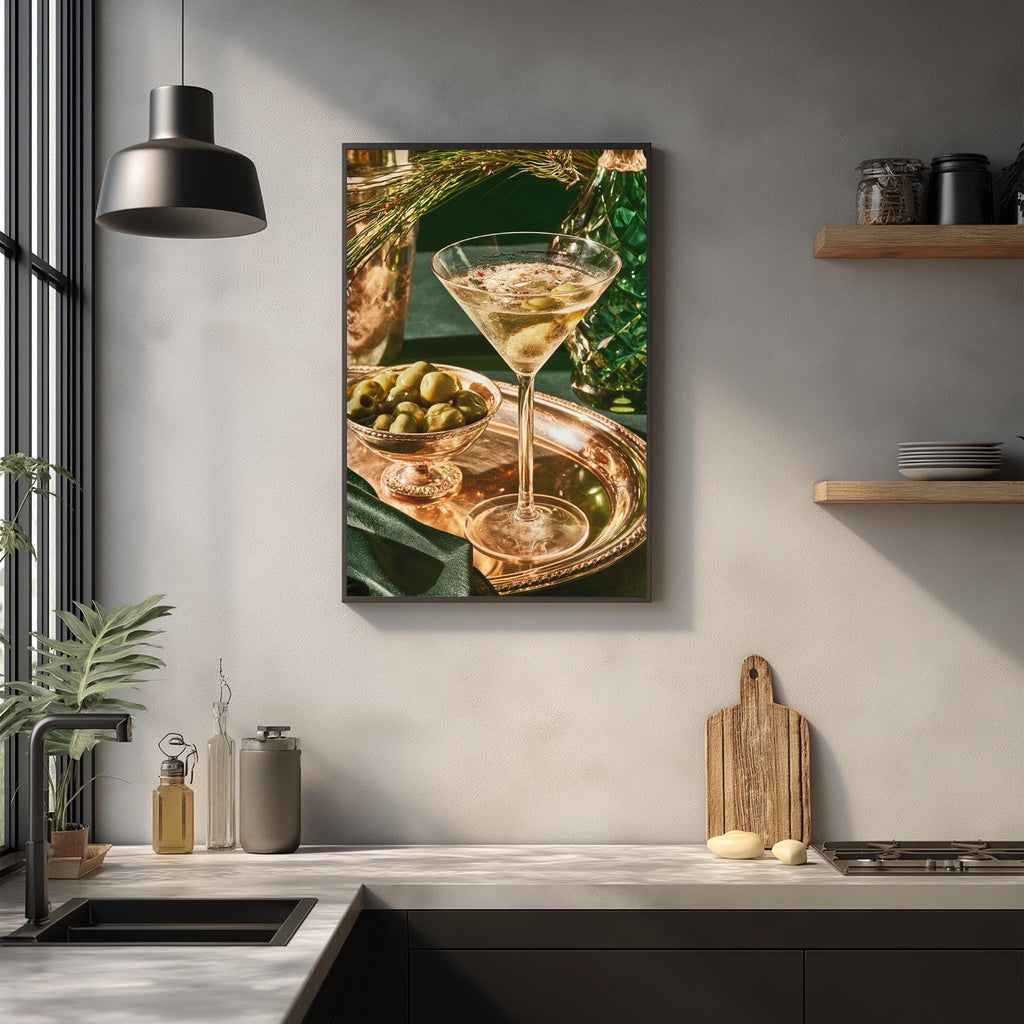 a kitchen counter with a framed photograph of a martini glass filled with a drink, a bowl of olives, and a wooden cutting board.
