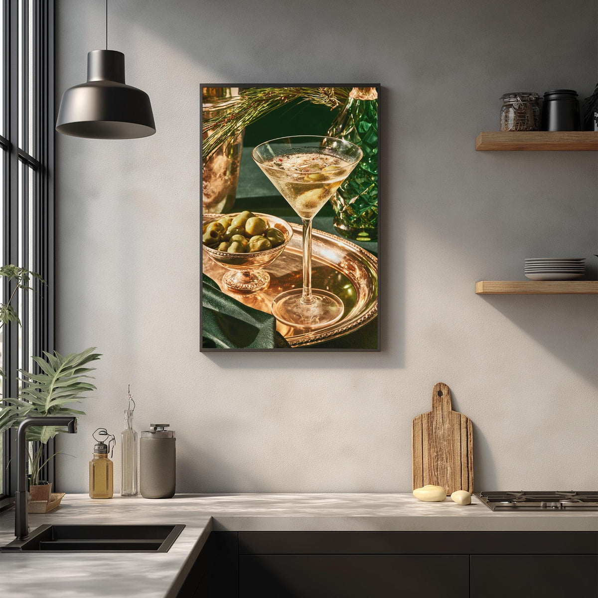 a kitchen counter with a framed photograph of a martini glass filled with a drink, a bowl of olives, and a wooden cutting board.