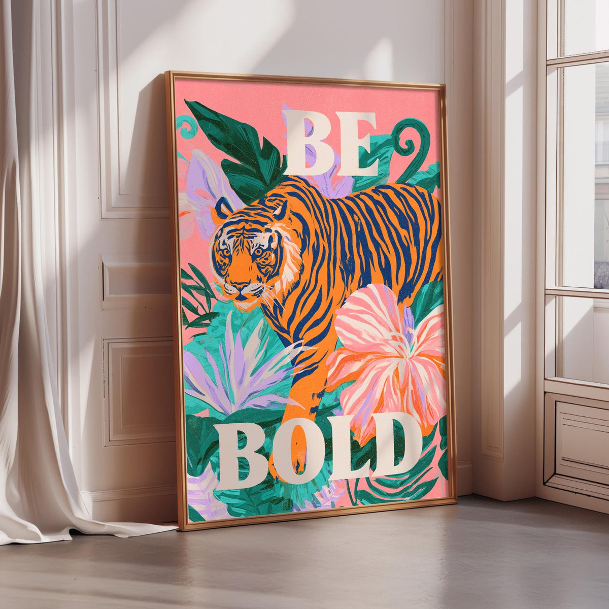 A framed poster with a vibrant illustration of a tiger surrounded by tropical foliage and flowers, with the text "BE BOLD" prominently displayed.