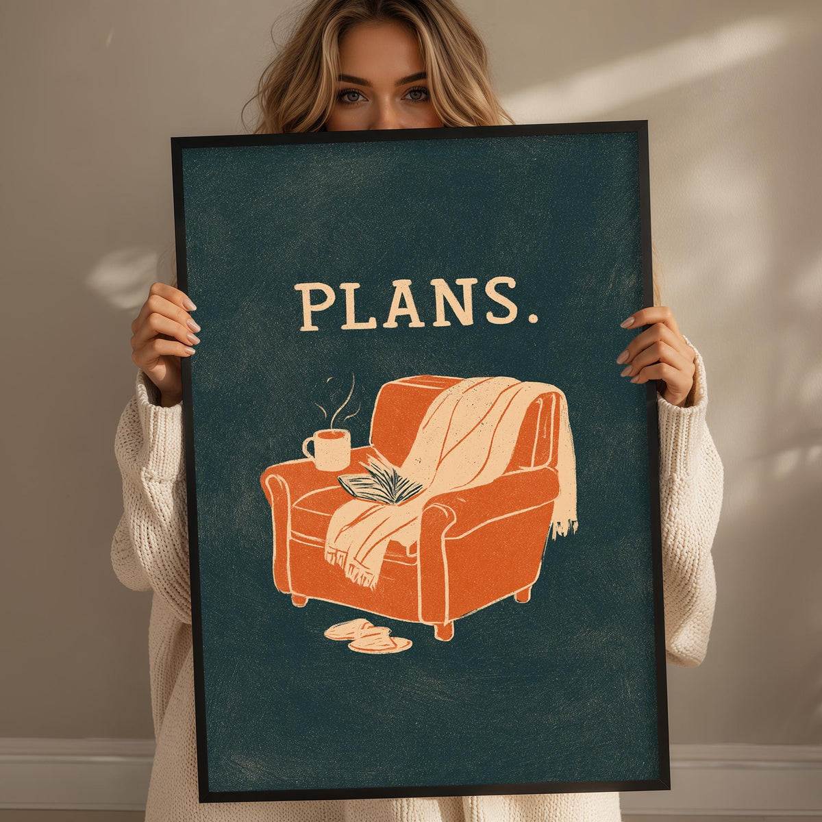 A woman holding a framed poster with an illustration of a chair and a book, with the word "PLANS" written above it.