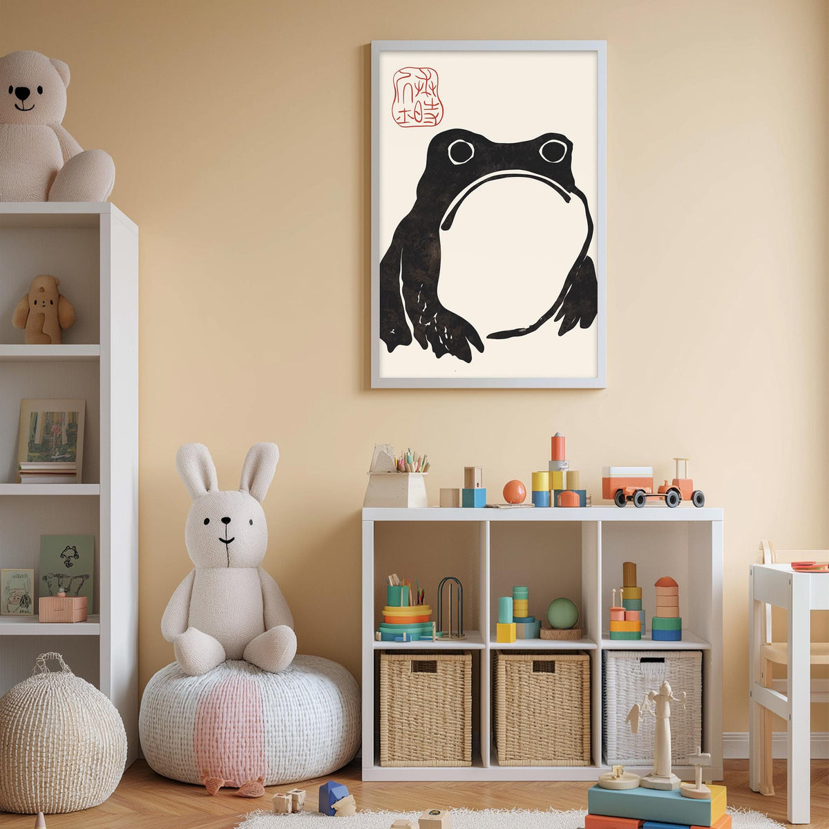A child's bedroom with a white bookshelf, a stuffed rabbit, a framed picture of a frog, and a toy train set.