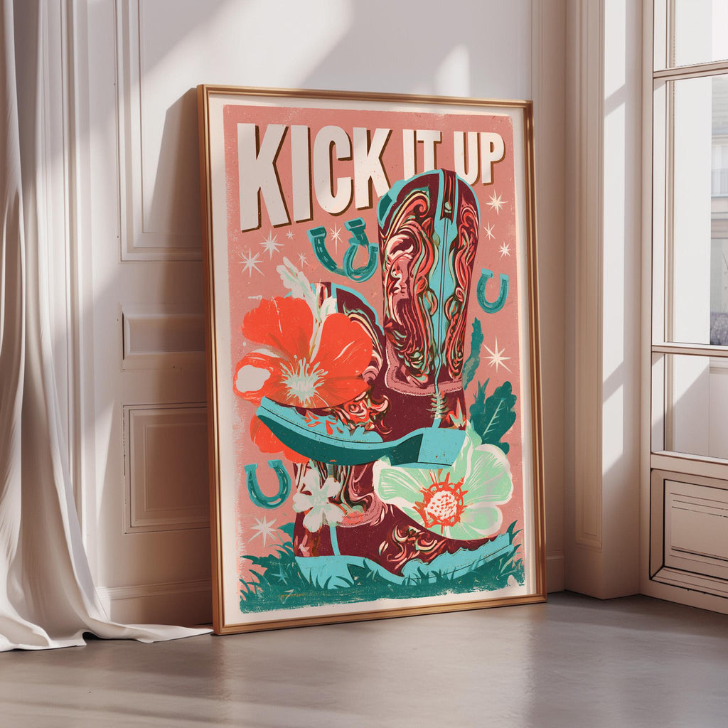 A framed poster with a vibrant design featuring a cowboy boot, flowers, and the text "KICK IT UP" is displayed on a wall.