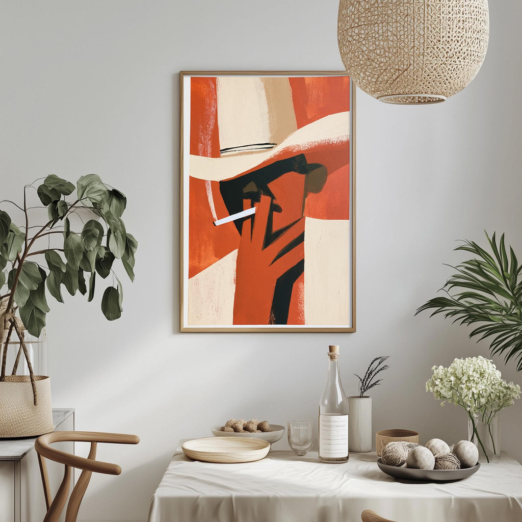 a dining table with a white tablecloth, a bowl of fruit, a bottle, and a vase with flowers. Above the table, there is a framed artwork depicting a person smoking a cigarette.