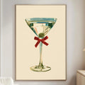 a framed illustration of a martini glass with a red ribbon, hanging on a wall in a living room setting.