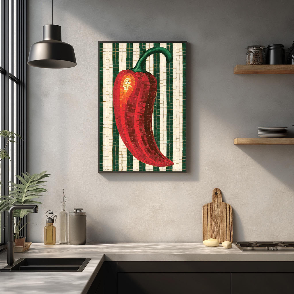 a kitchen counter with a framed mosaic of a red pepper on the wall above it. The counter also has various kitchen items such as a cutting board, a bottle, and a bowl.