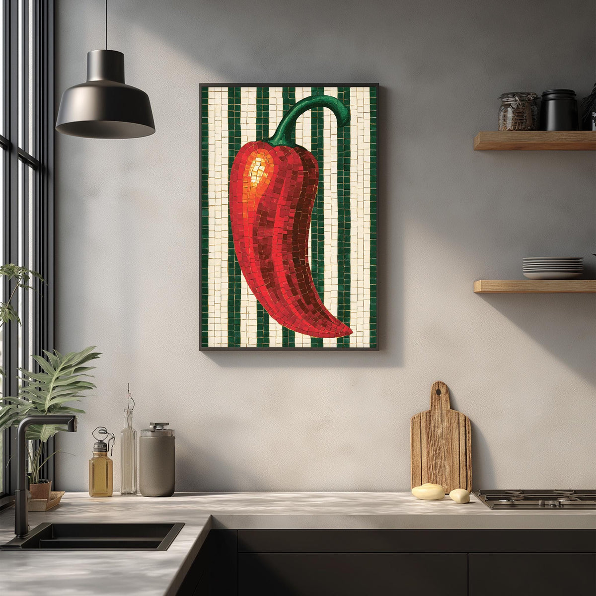 a kitchen counter with a framed mosaic of a red pepper on the wall above it. The counter also has various kitchen items such as a cutting board, a bottle, and a bowl.