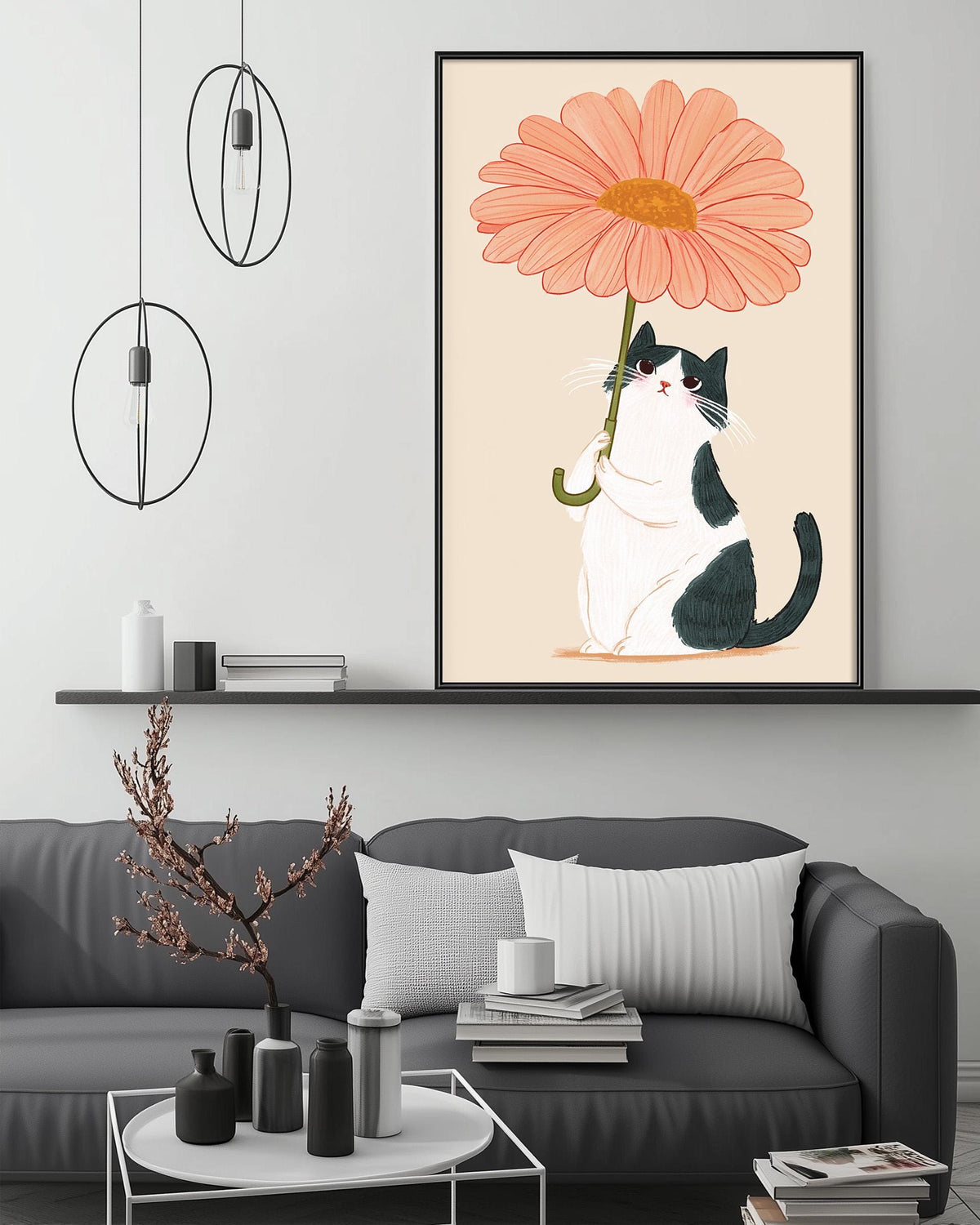 a black and white cat sitting on a couch, holding a large orange flower in its paws. The cat is sitting on a white pillow, and there is a large framed picture of a flower hanging on the wall above the couch.