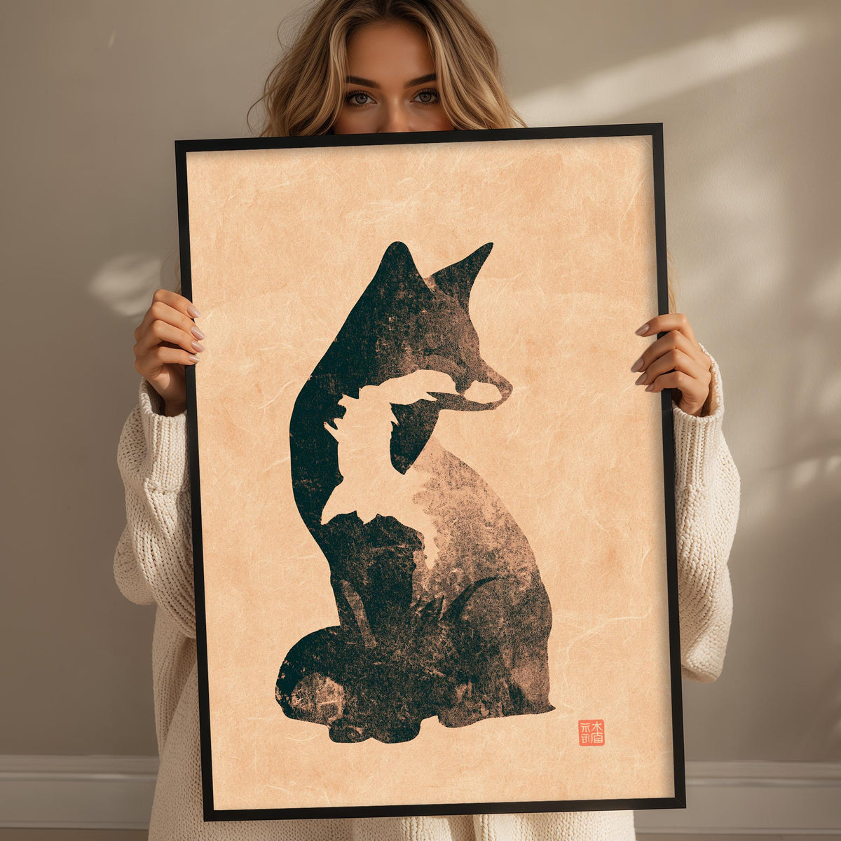 A woman holding a framed print of a cat silhouette.