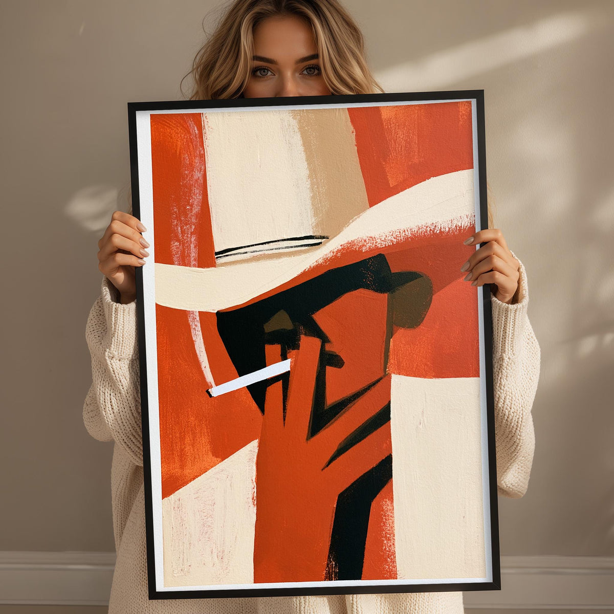 A woman holding a framed abstract painting of a man's face.