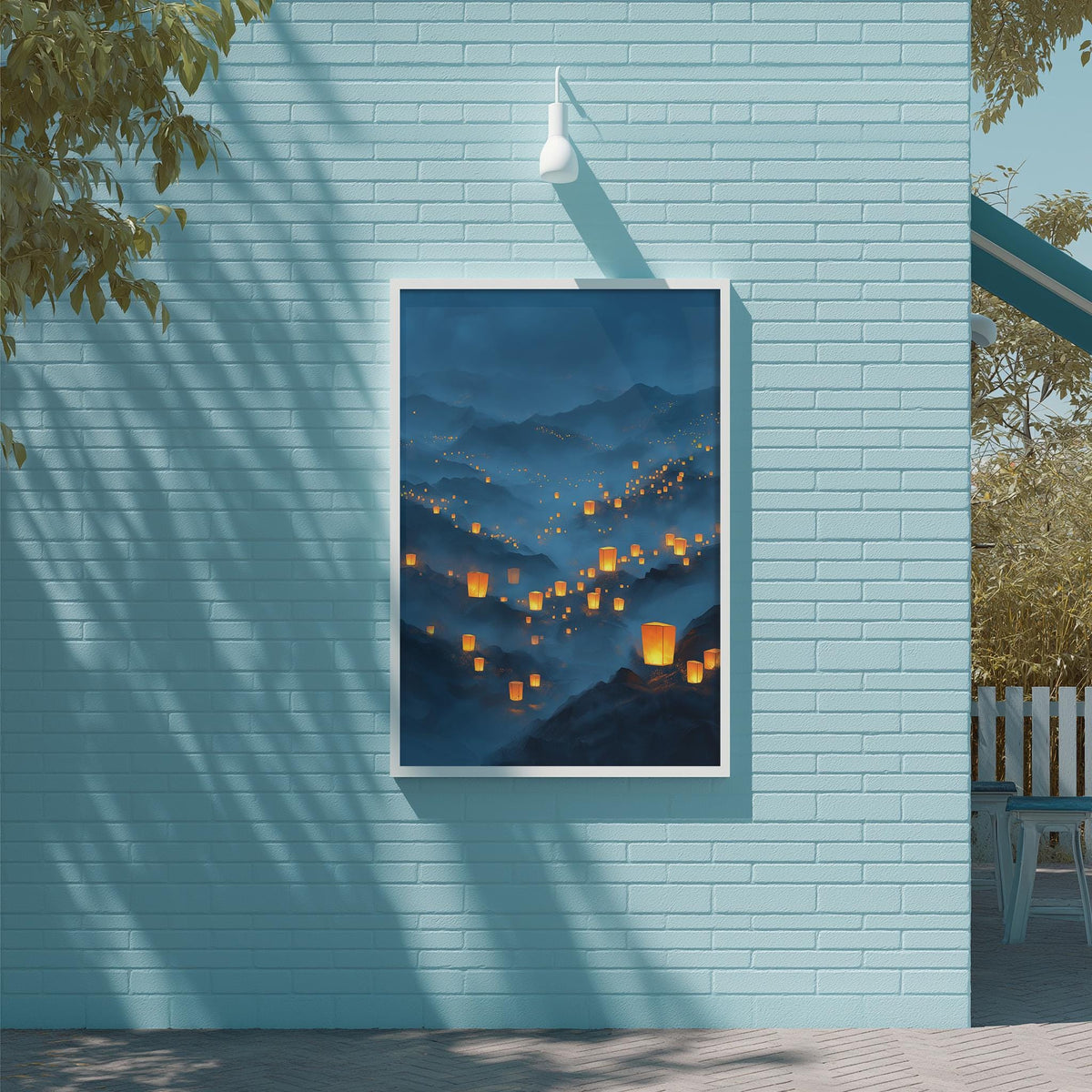 a blue brick wall with a framed painting of a mountainous landscape with orange lanterns hanging from the peaks.