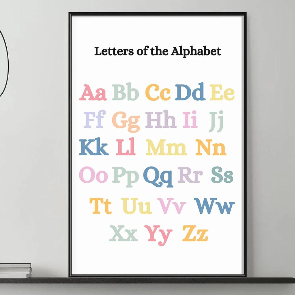 a poster of the alphabet hanging on a wall above a gray couch with a coffee table in front of it.