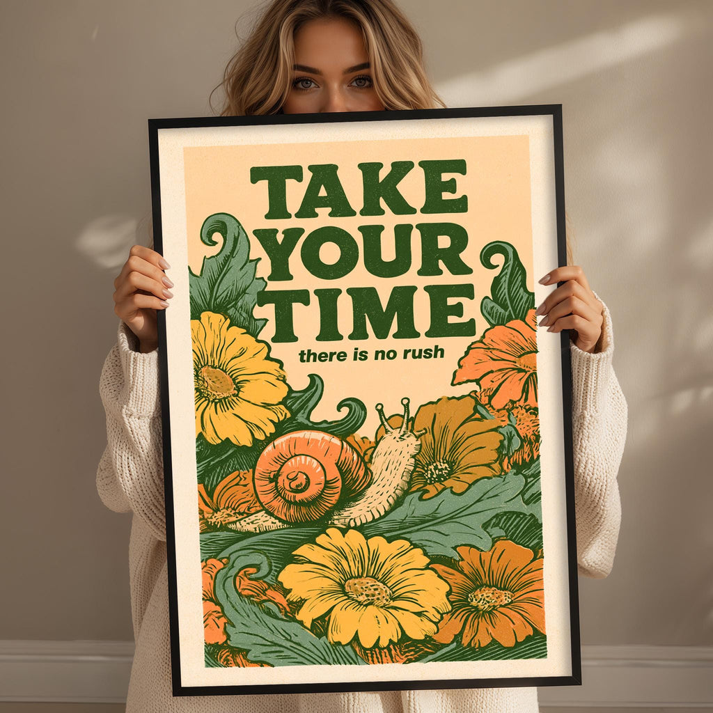 A woman holding a framed poster with a colorful illustration of flowers and a snail.