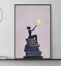 a cozy living room with a gray sofa, a coffee table, and a large framed poster of a woman sitting on a stack of books with a star above her.