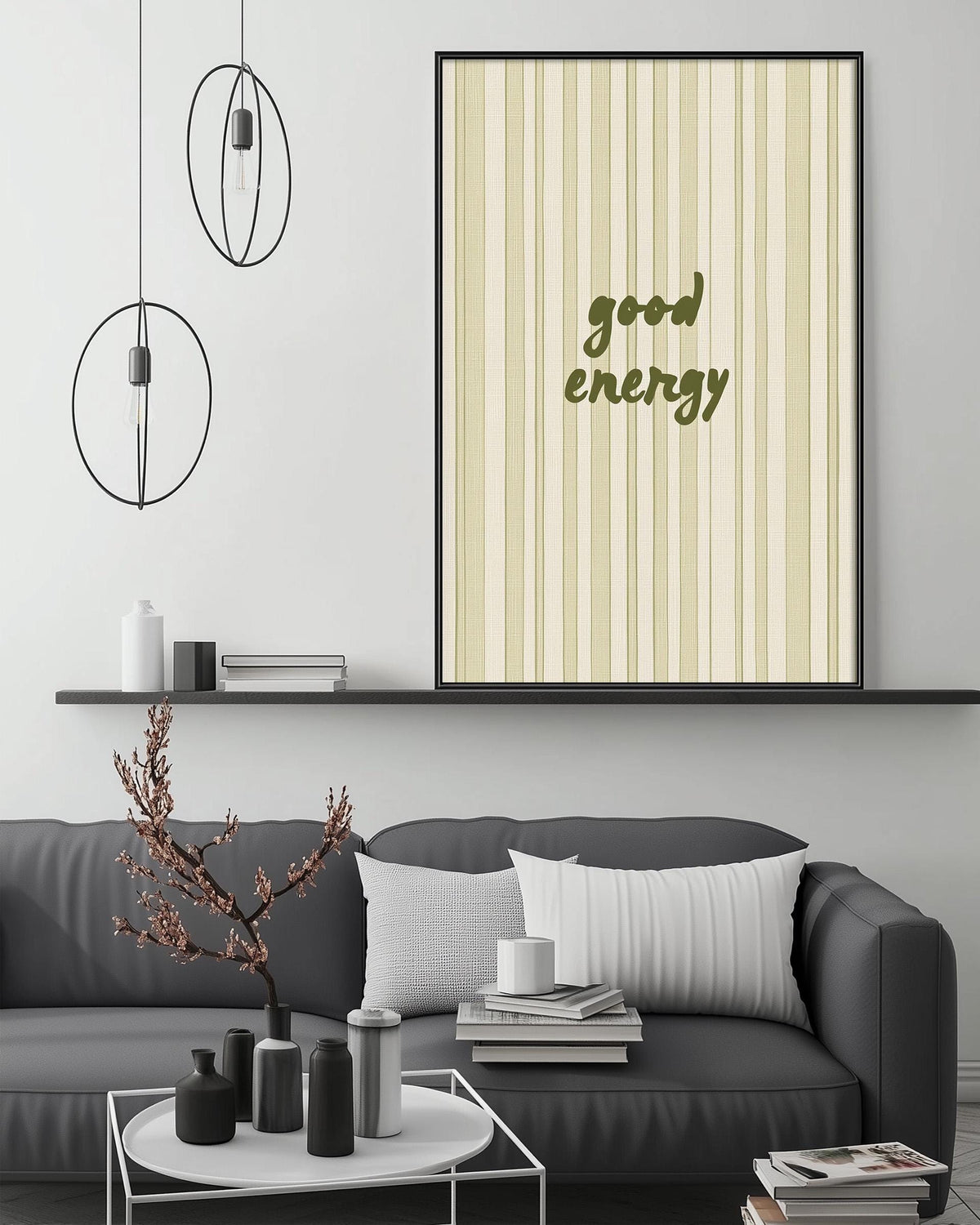 a modern living room with a gray sofa, a coffee table, and a framed poster with the text "good energy" on the wall.