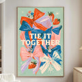 a living room with a large framed poster on the wall that says "tie it together" surrounded by colorful flowers and a star.