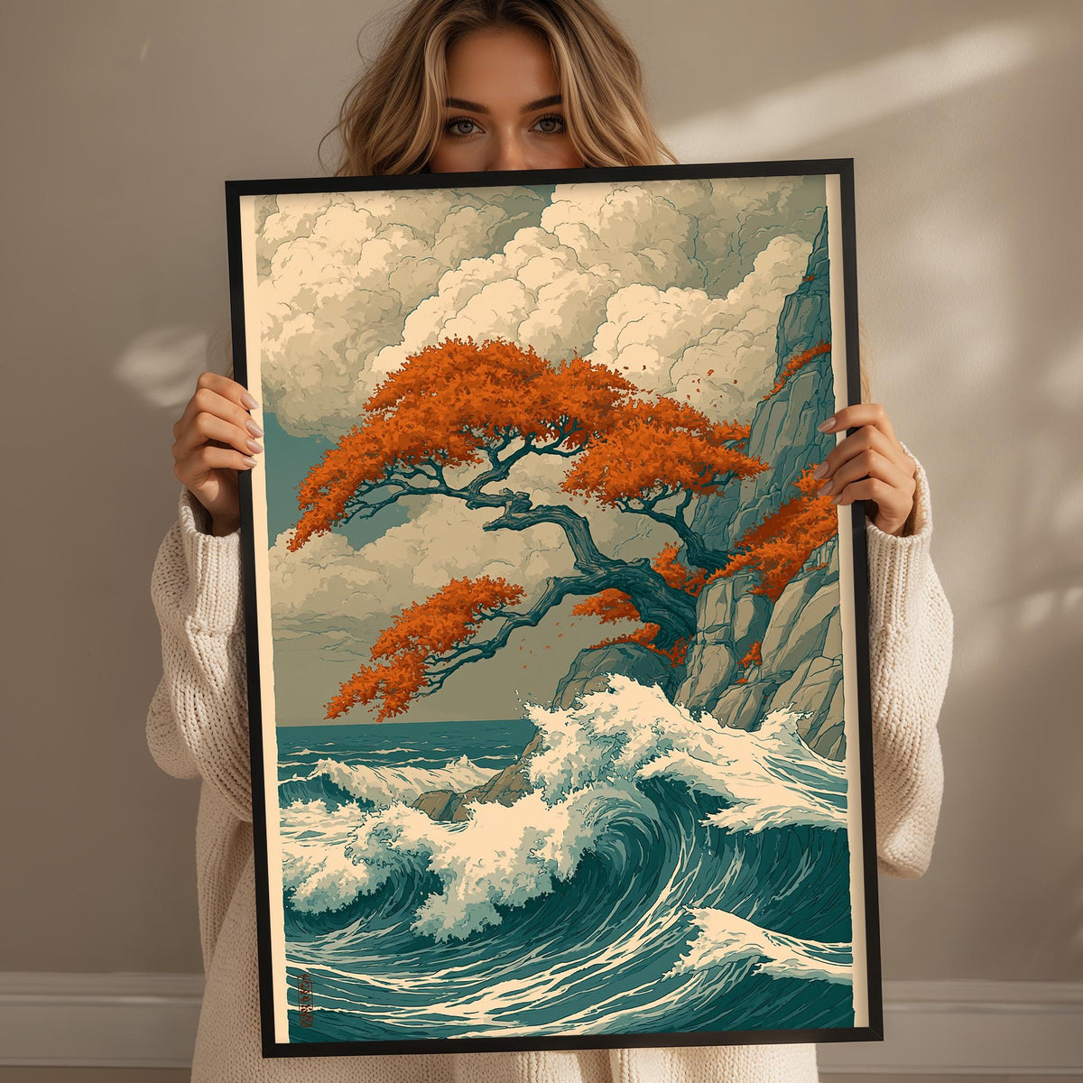 A woman holds up a framed print of a vibrant, colorful landscape depicting a tree with orange leaves, a crashing wave, and a cloudy sky.