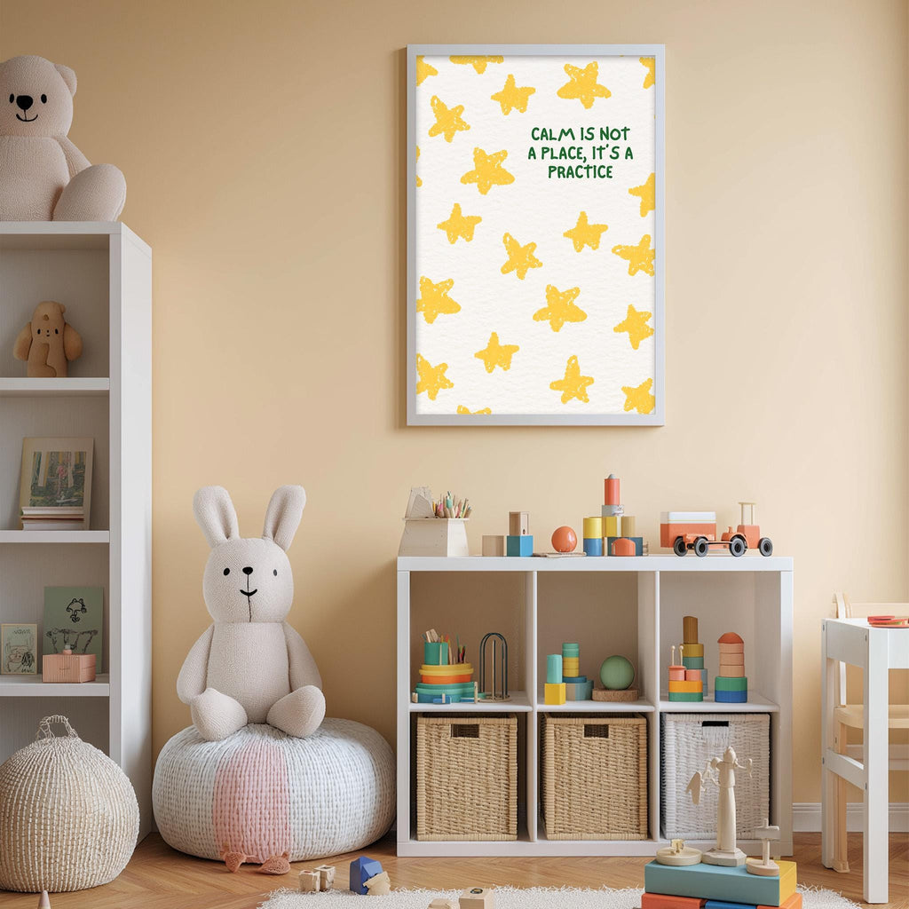 A child's bedroom with a white bookshelf, a stuffed rabbit, and a toy train. Above the bookshelf is a framed poster with the text "Calm is not a place, it's a practice" and a pattern of yellow stars.