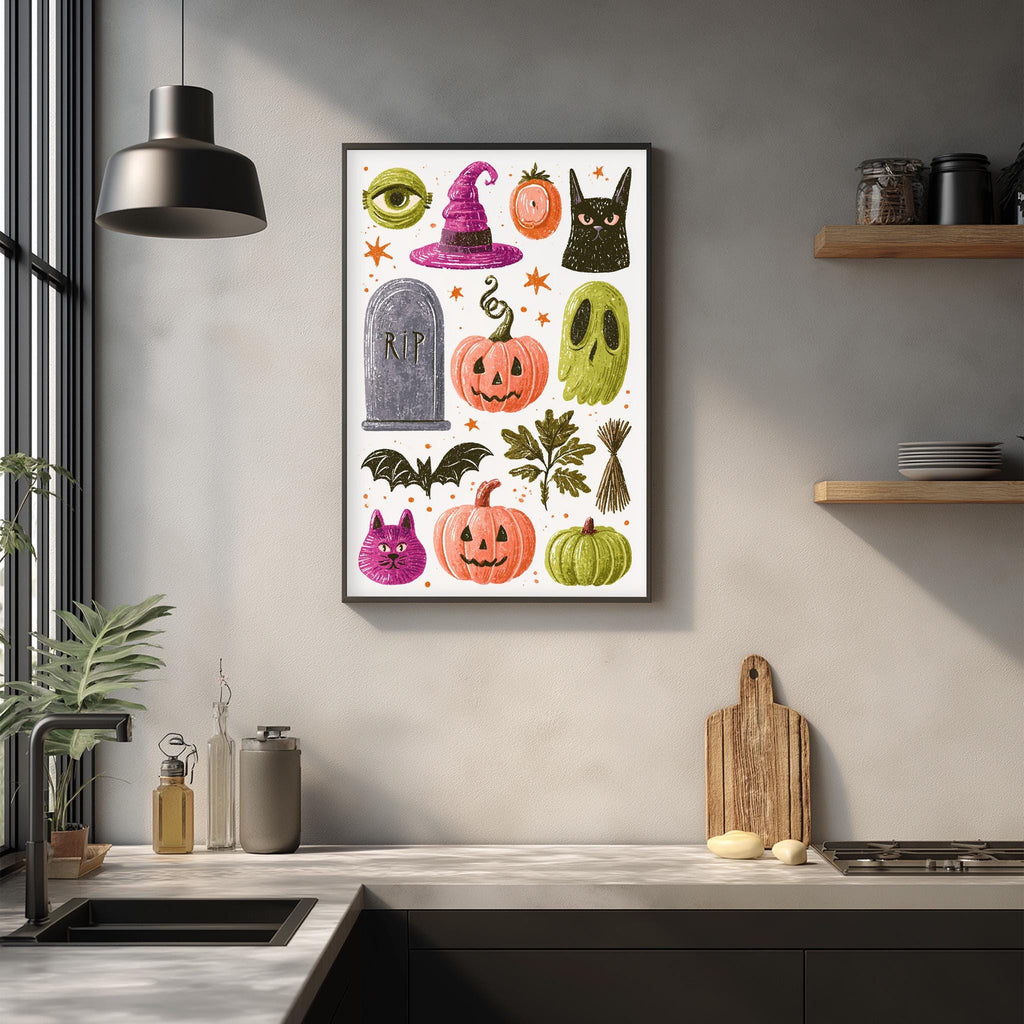 a kitchen counter with various Halloween-themed items, including a framed illustration of Halloween symbols, a wooden cutting board, and a potted plant.