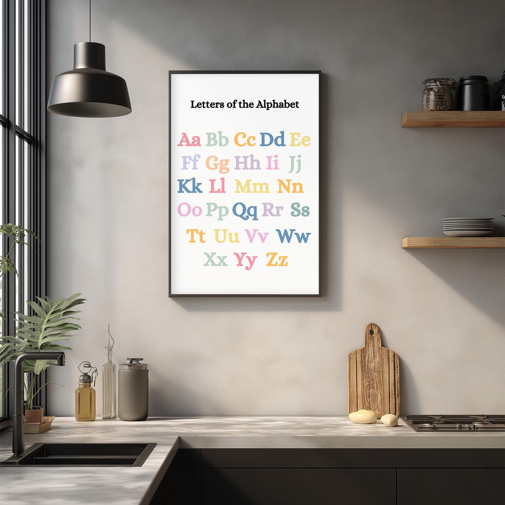 a kitchen counter with various kitchen items, such as a cutting board, a soap dispenser, and a bottle. Above the counter, there is a framed alphabet poster hanging on the wall, which displays the letters of the alphabet in a colorful and visually appealing manner.
