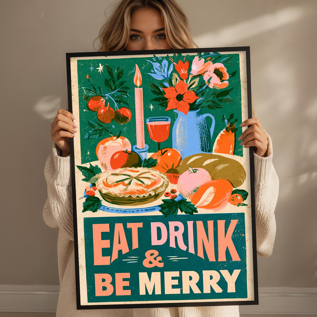 A woman holds up a framed poster with a colorful illustration of food and drink items, along with the text "EAT DRINK & BE MERRY".