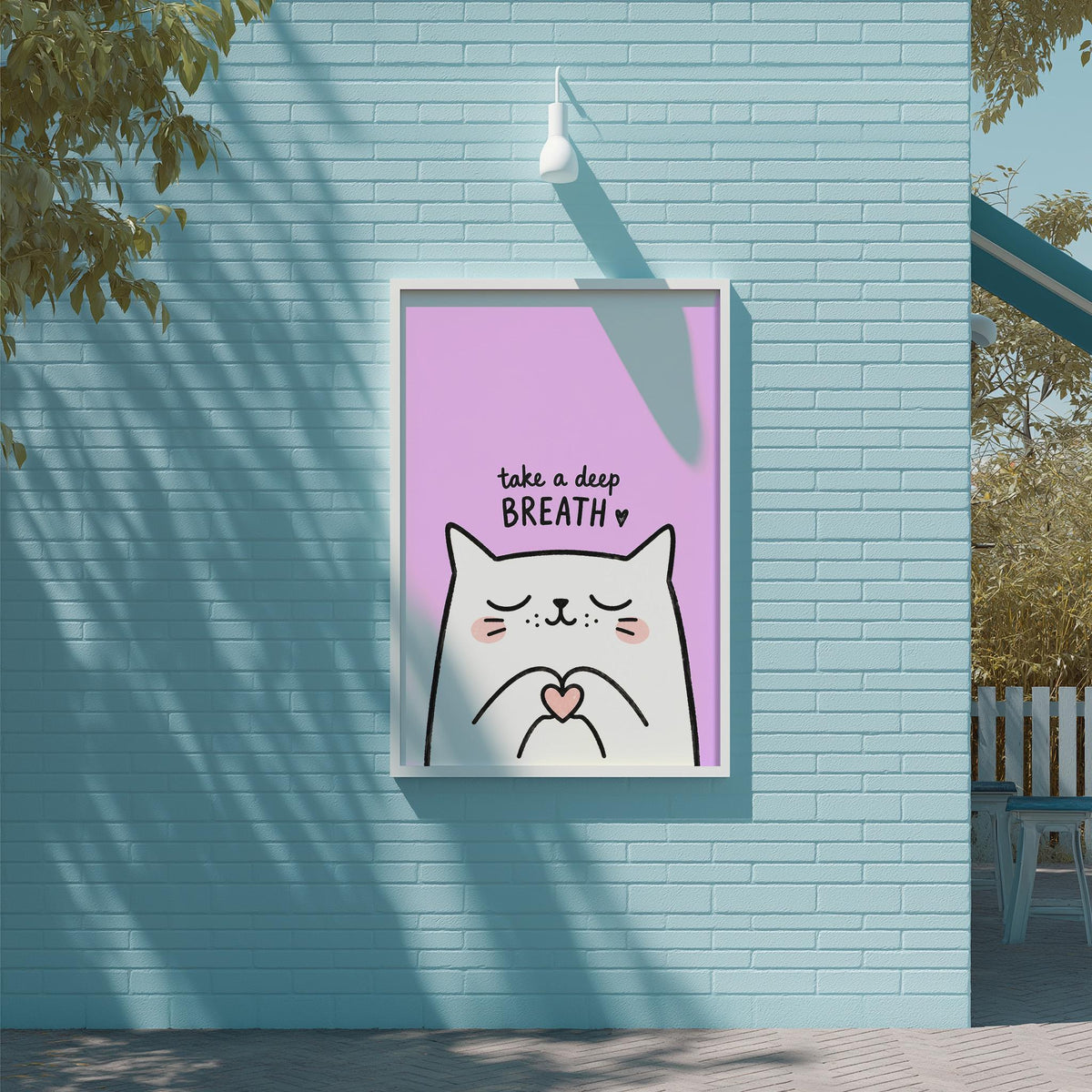 A framed poster with a cartoon cat and the text "Take a deep breath" is displayed on a light blue brick wall.
