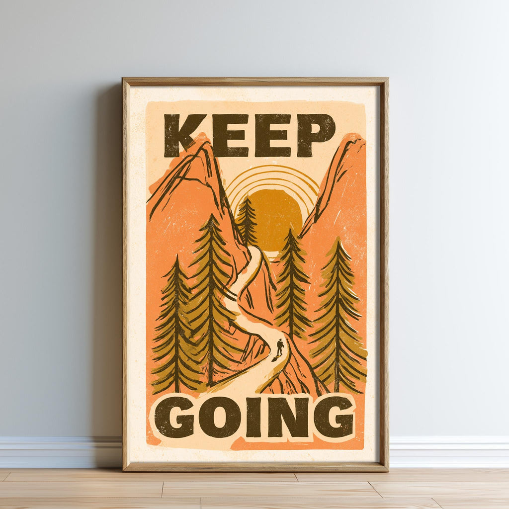 The image is a framed poster with a mountain landscape and a person walking along a path. The poster has the text "KEEP GOING" prominently displayed.